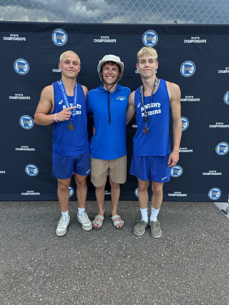 Levi Freyberg, Jackson Nesmoe and Jacob Miller standing in front of a MSHSL banner with medals on  smiling at the camera.