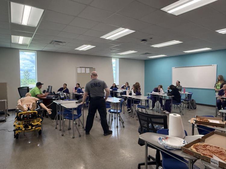 students in classroom looking at “dummies” for CPR  