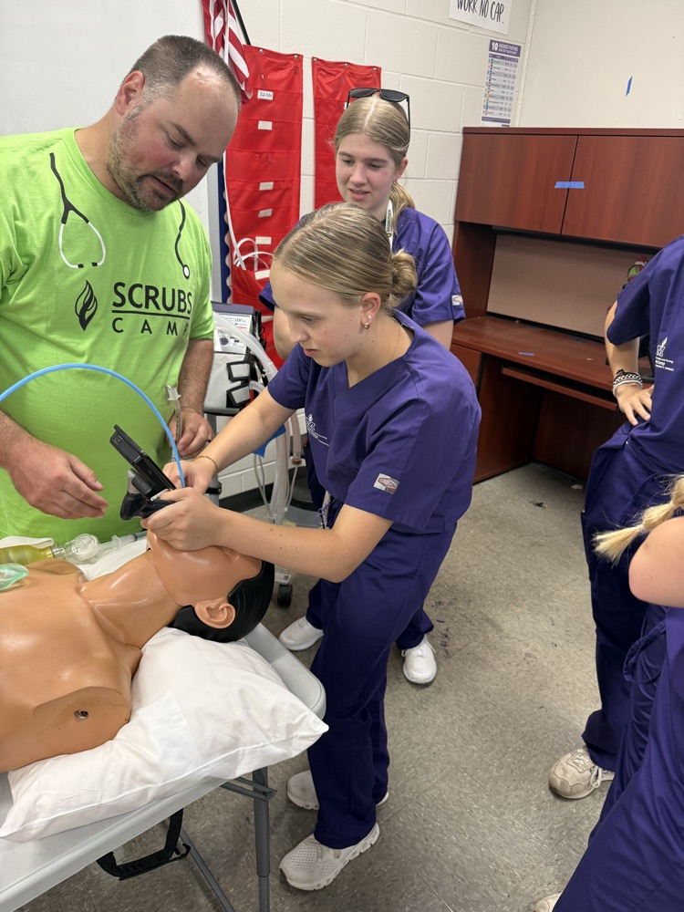 STUDENTS PRACTICING INTUBATING A DUMMY 