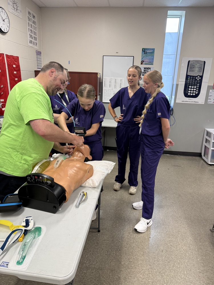 STUDENTS PRACTICING INTUBATING A DUMMY 