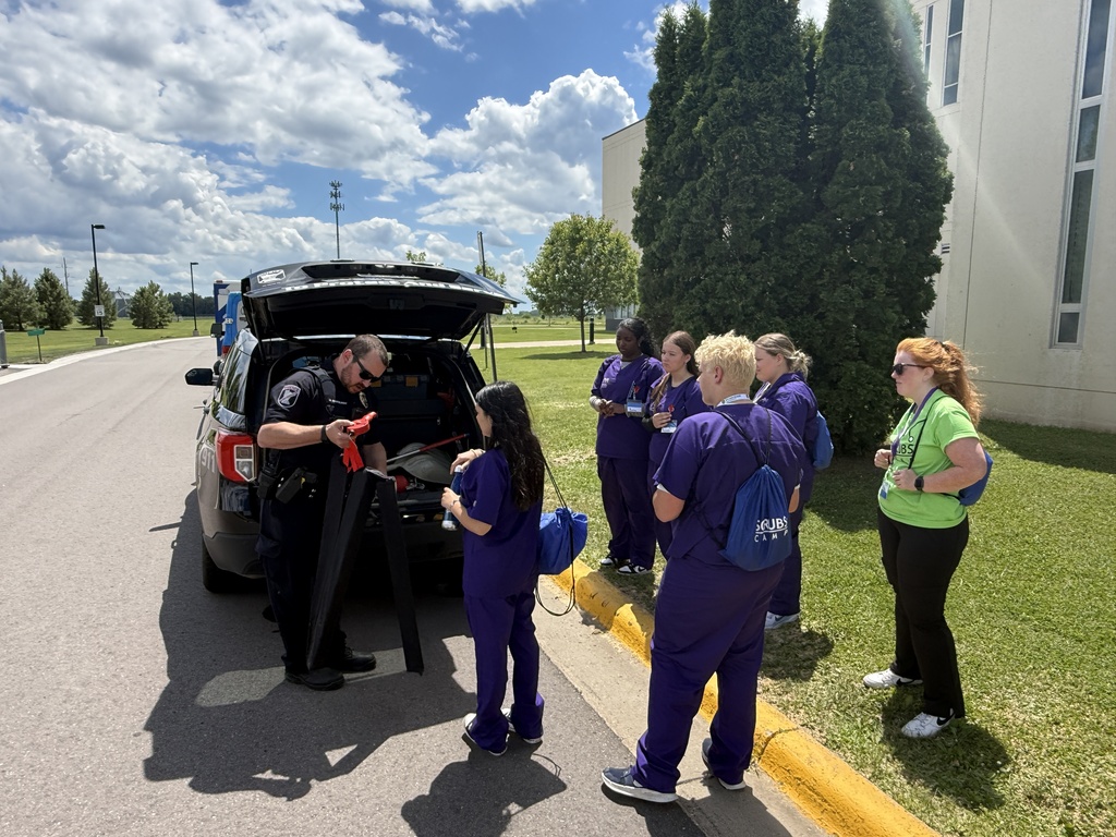 Students looking in back of squad car learning about police officers responsibilities from the Lake Crystal Police Dept.