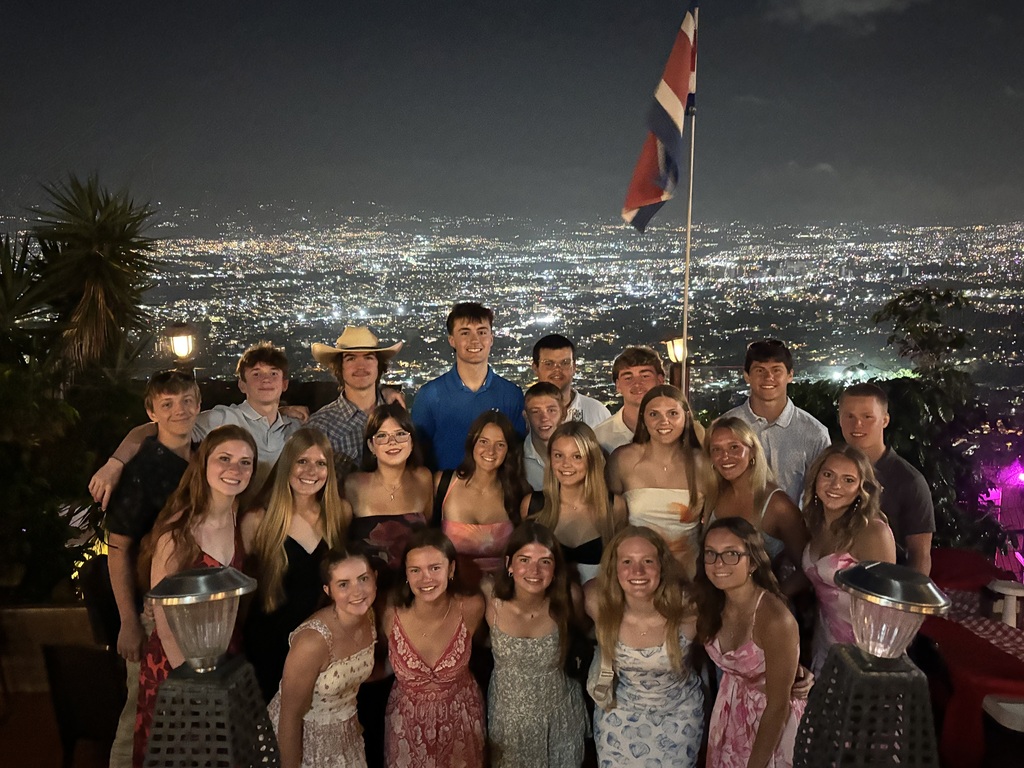 students posing in front of the Costa Rica skyline.