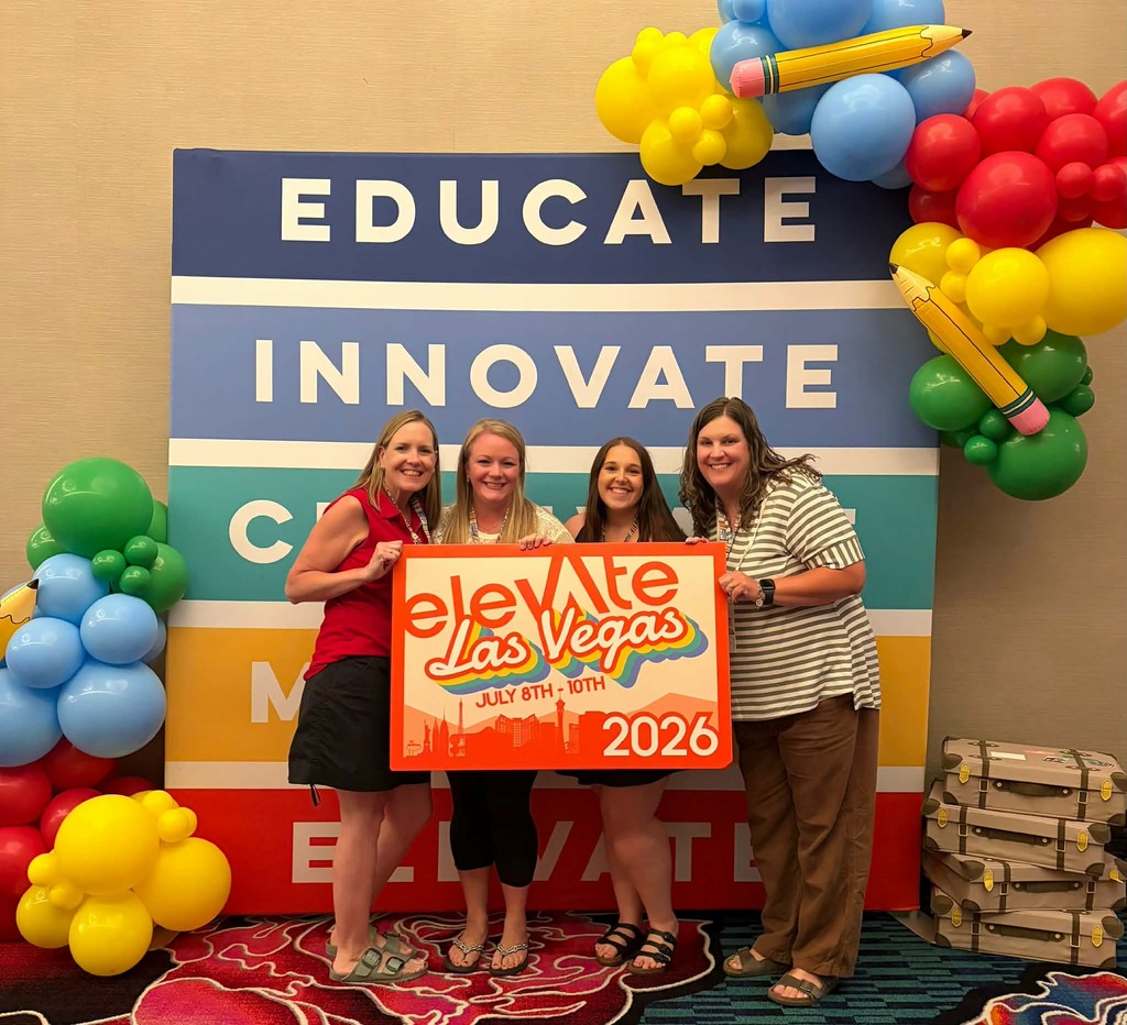 Teachers standing in front of a backdrop that says Educate, innovate holding a sign that says Elevate Las Vegas 2026.