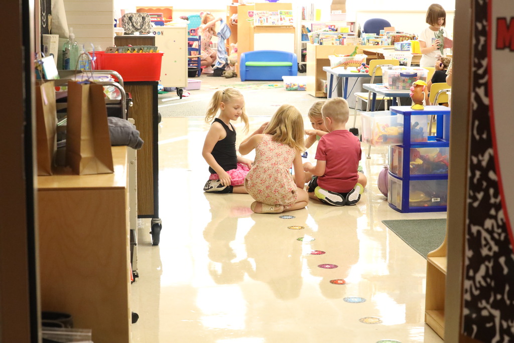 students playing in a circle in the kindergarten classroom. 