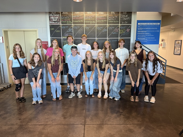 student council members posing in front of a blackboard at the rec center after their luncheon