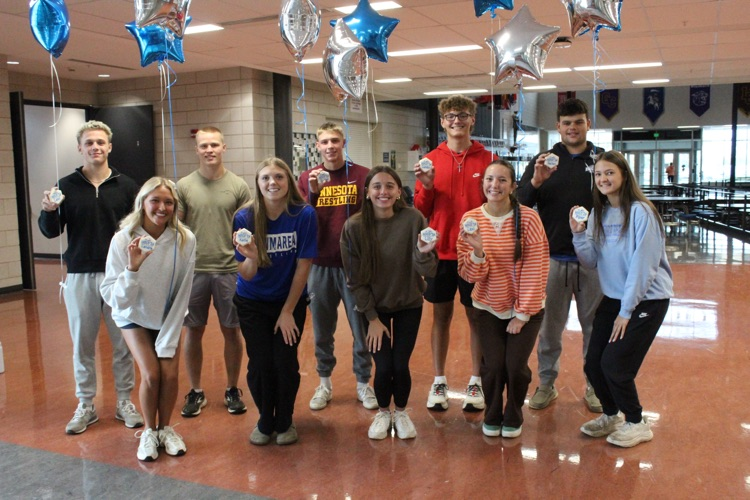 homecoming candidates lined up in two lines holding helium balloons
