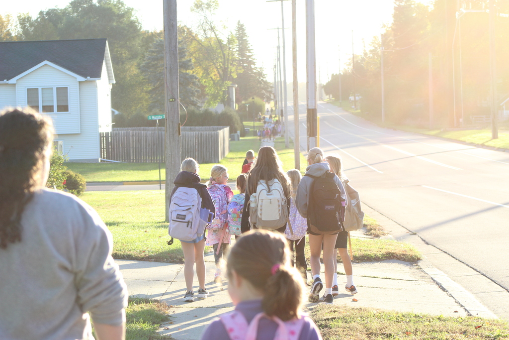 Students walking to school with their backs to the camera.