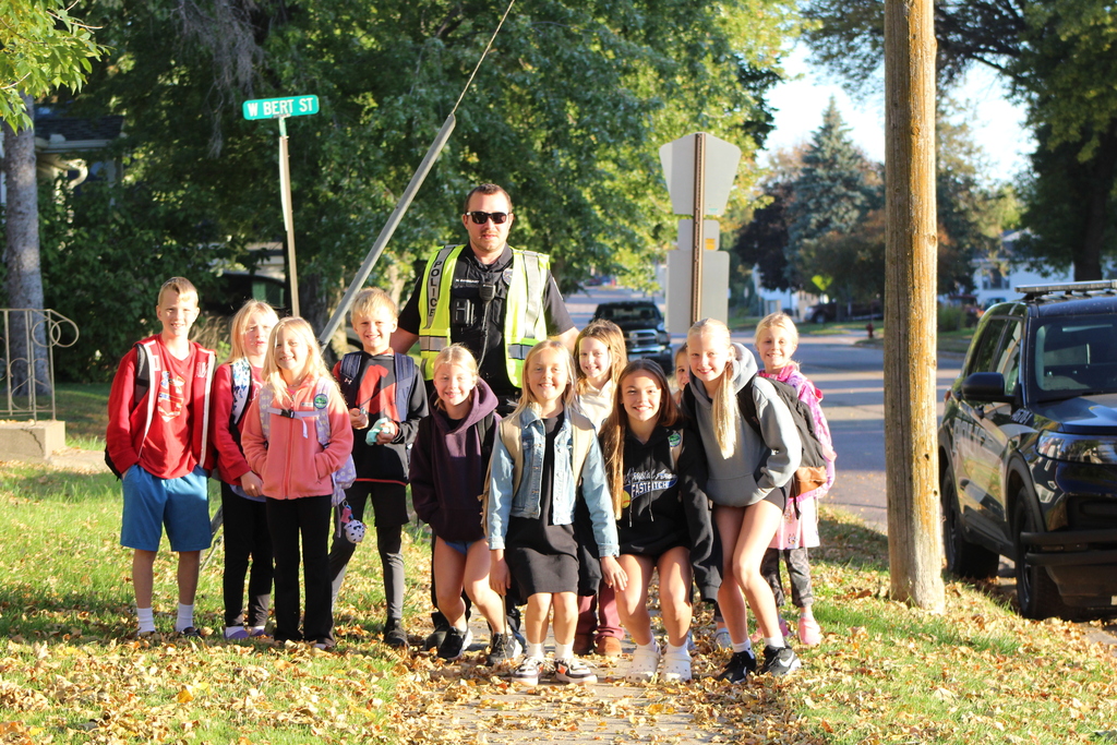 students posing and smiling with Officer Gangelhoff.
