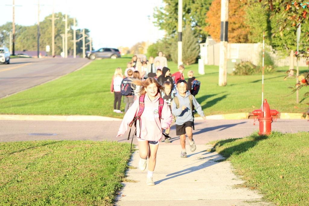 students running across the street towards school.