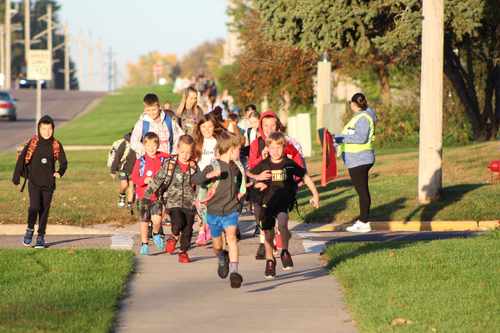 students running across the street towards school.