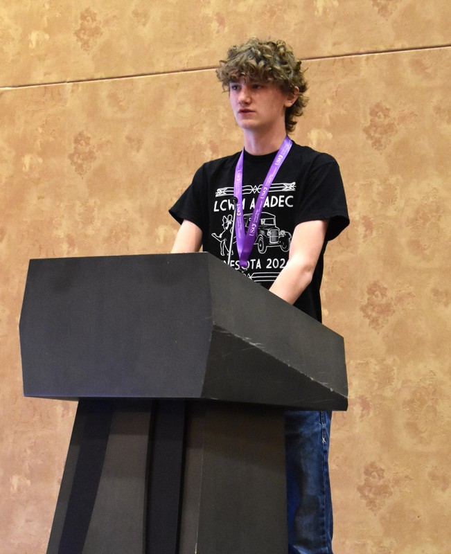 Student standing behind podium giving a speech
