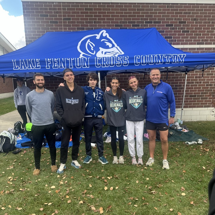 cross country team posing with coaches