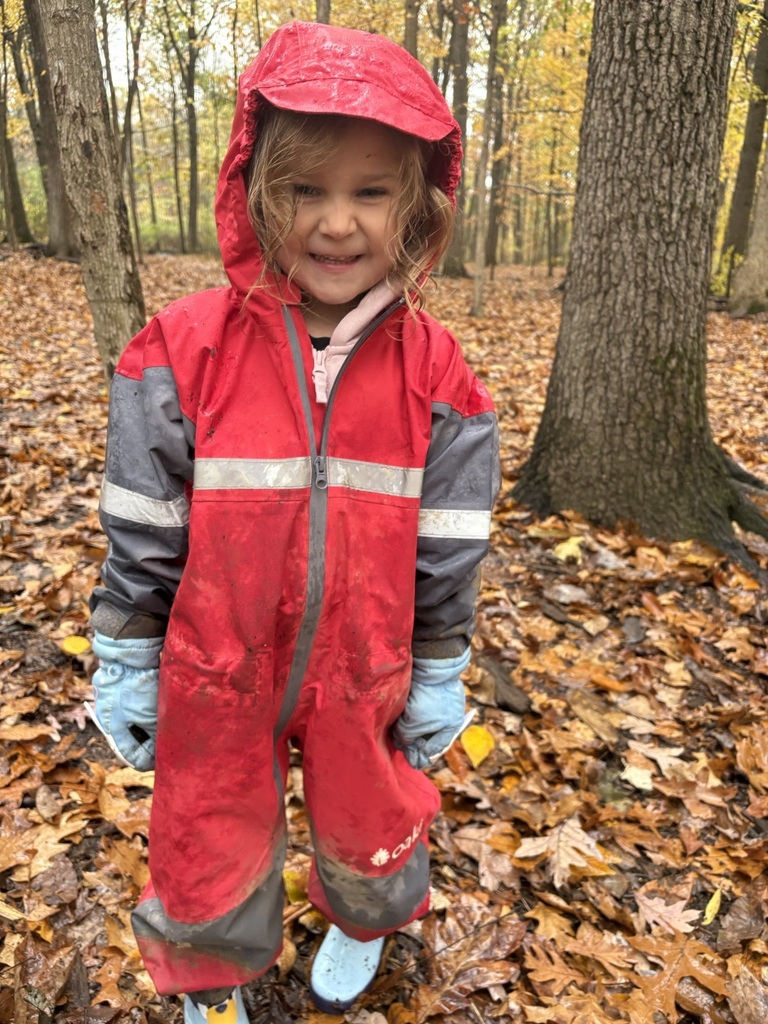 child posing in red rainsuit