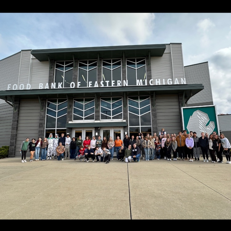 group posing in front of a food bank