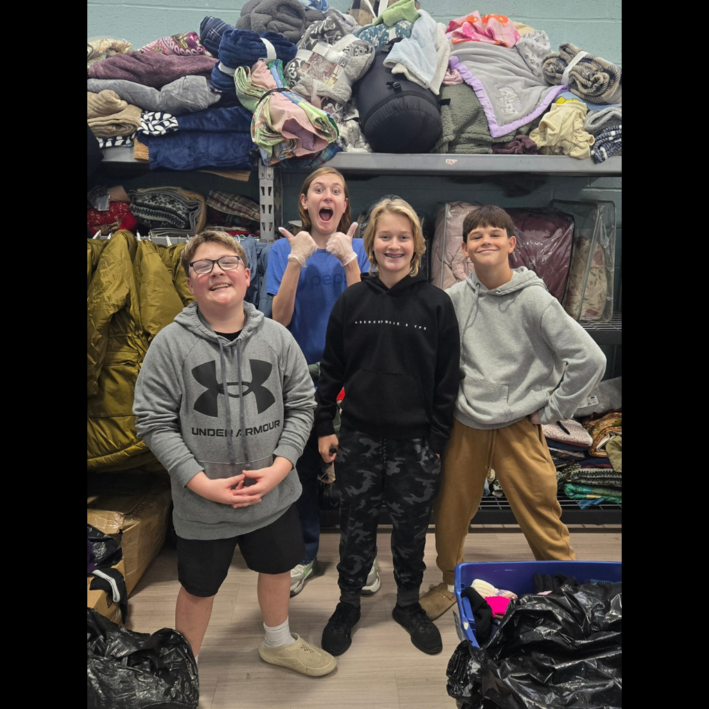 kids posing in a room with bags of clothes