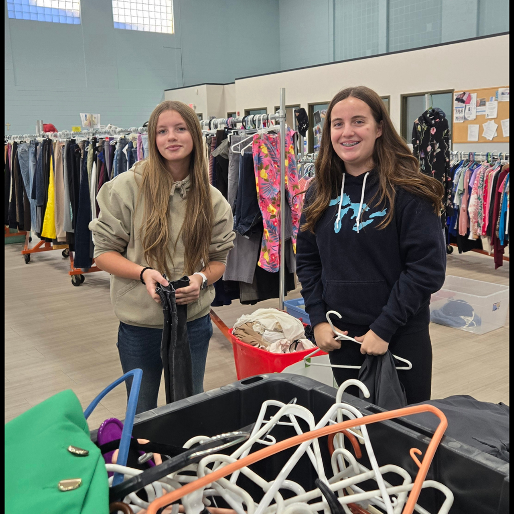 kids posing in a room with lots of clothes