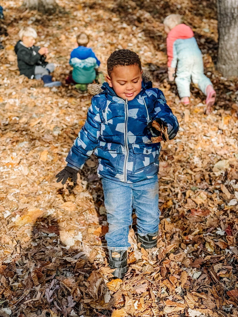 little kids playing in leaves