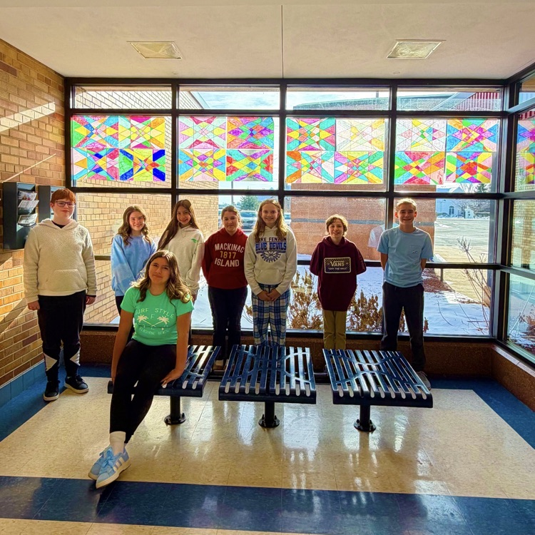 students standing in front of home made stained glass 