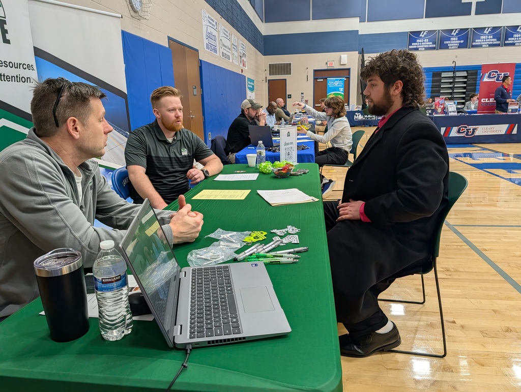 student talking to 2 men at a job fair