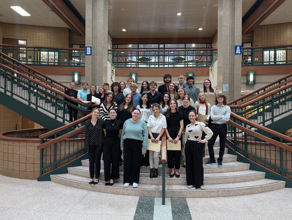 group of students posing on stairs in a high school