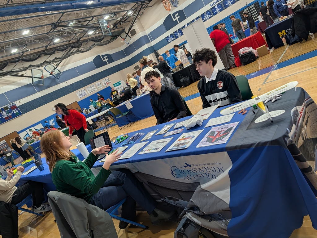 2 students talking to a womam at a job fair