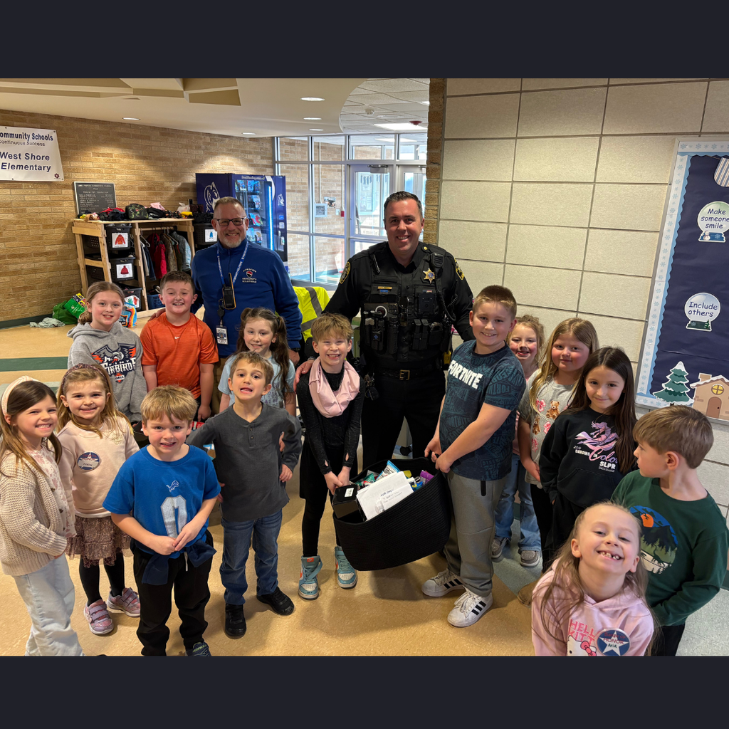 police officer and a security guard posing with a group of children