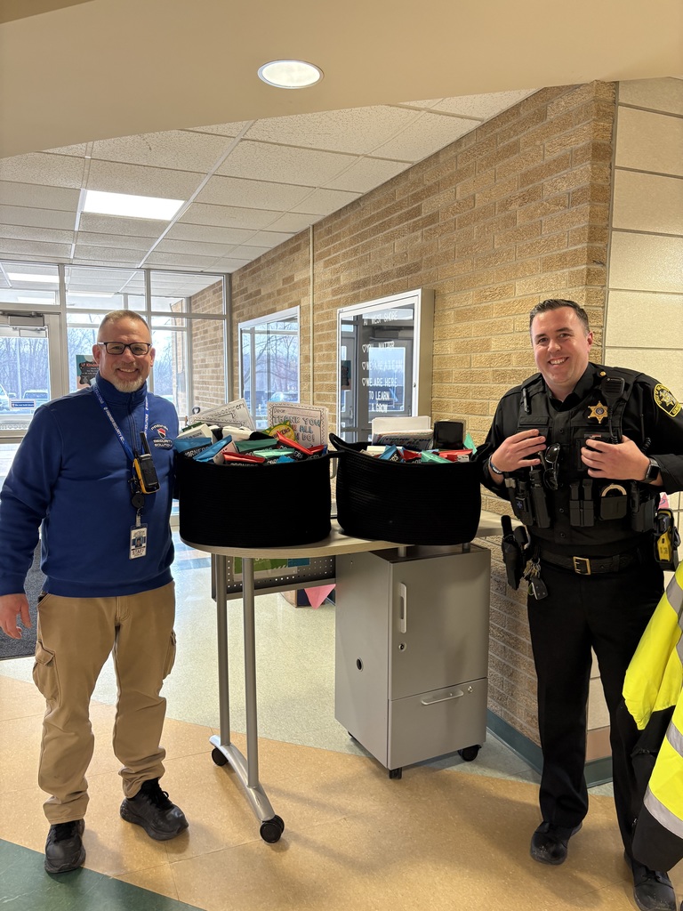 a police officer and a security guard posing with gift baskets