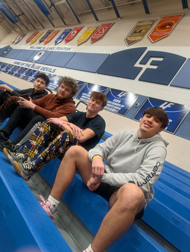 4 boys posing on bleachers