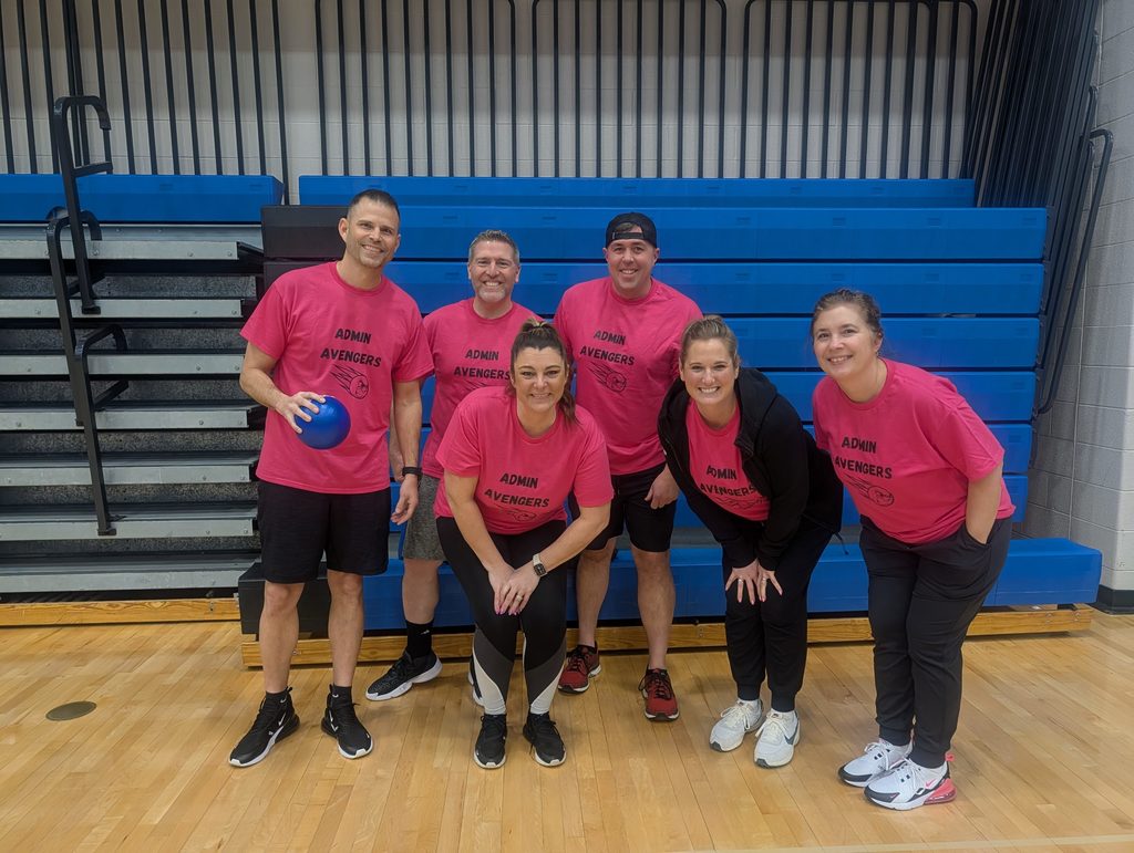 group of adults posing in pink shirts