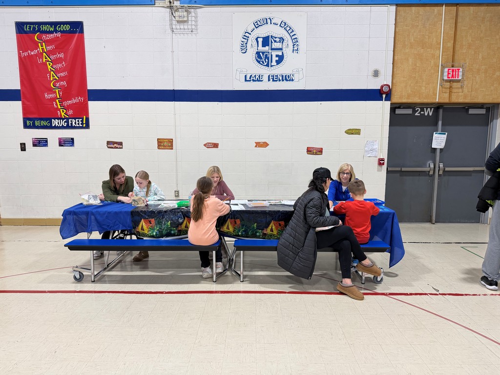 families sitting at a table in a gym