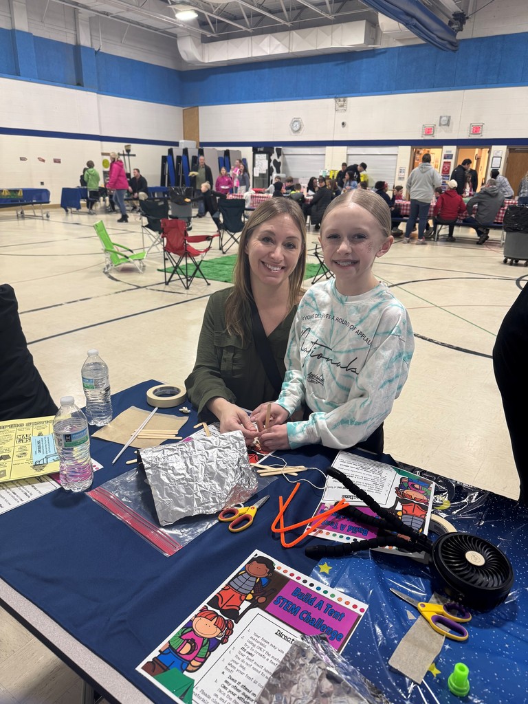 woman and daughter smiling at a craft station