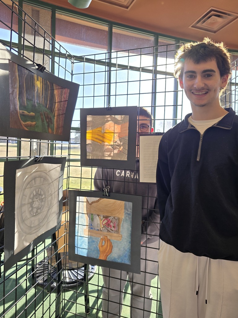 student standing with artwork