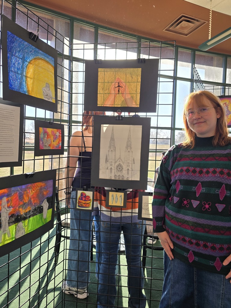 high school student standing in front of art work