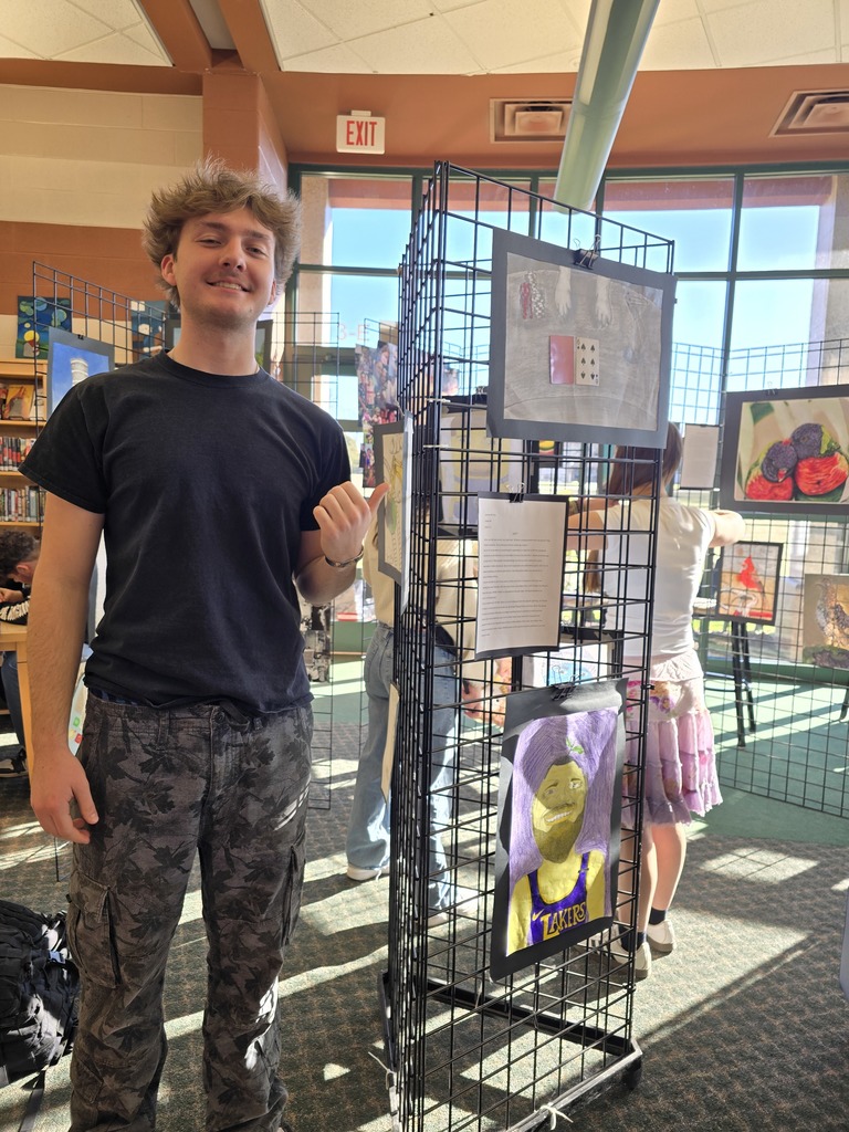 high school student standing in front of art work