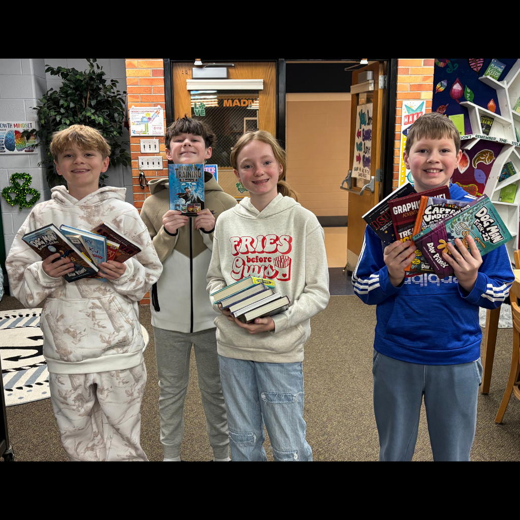 middle school students posing with books