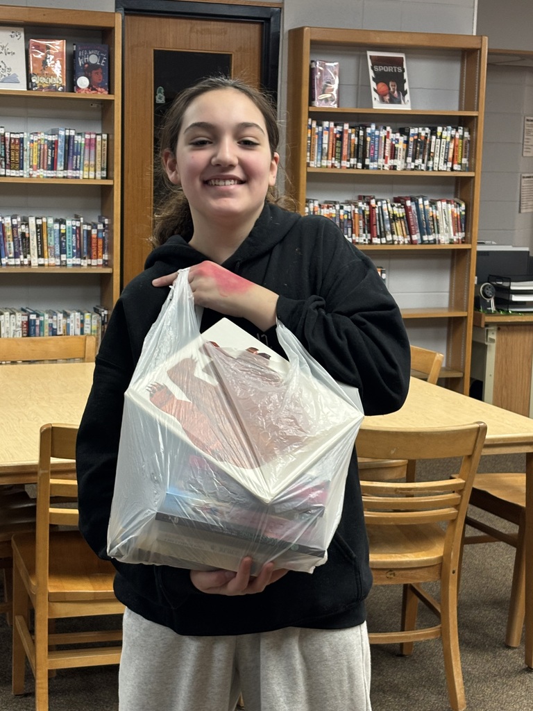 middle school student posing with books