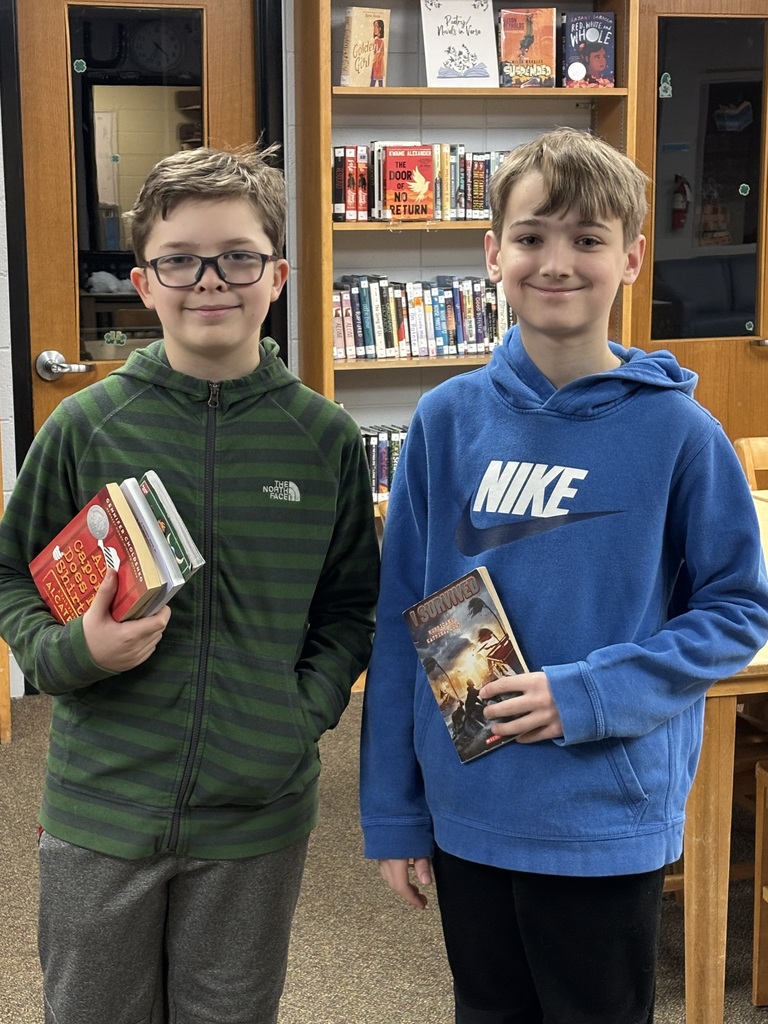 middle school students posing with books