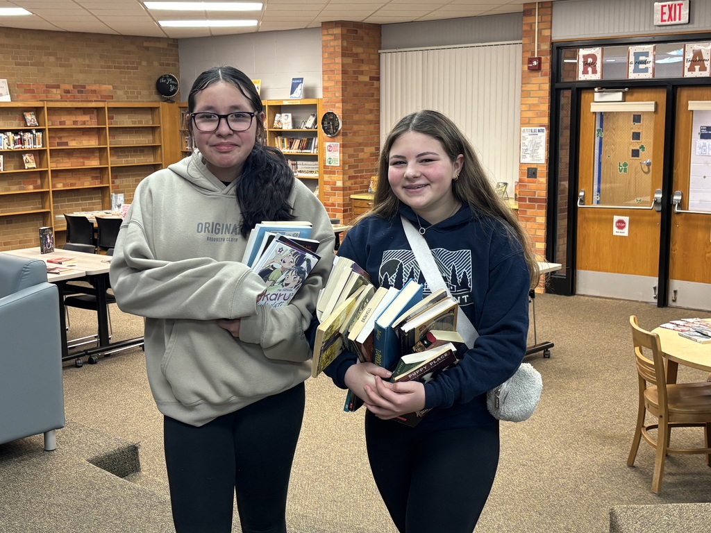 middle school students posing with books