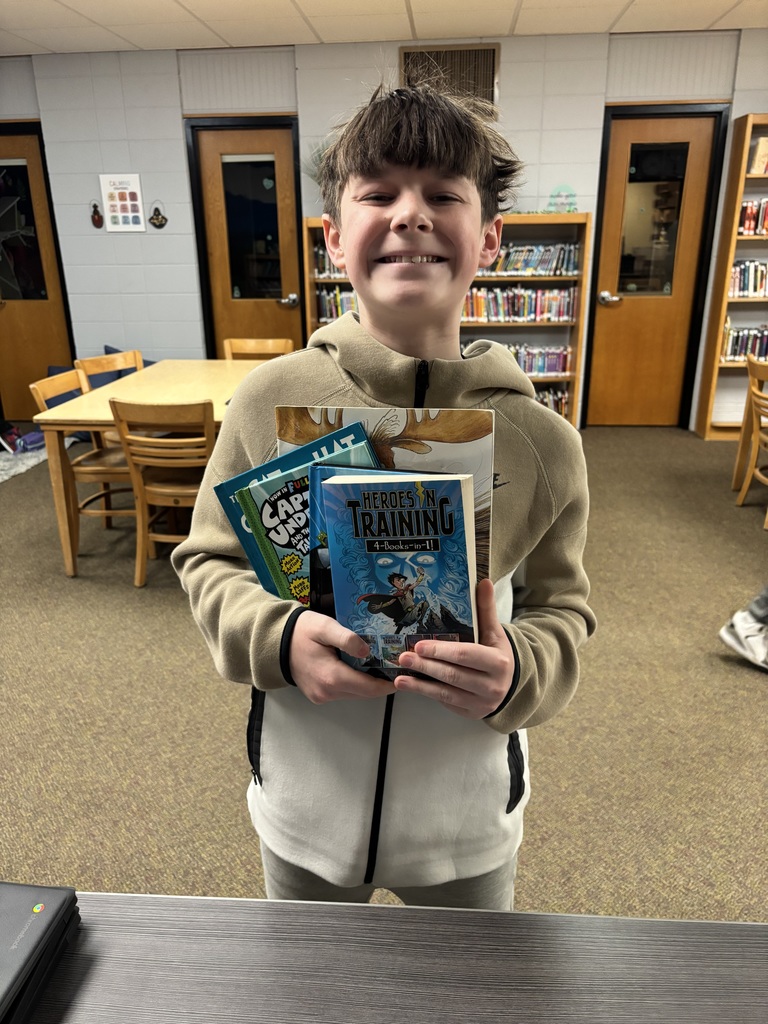 middle school student posing with books