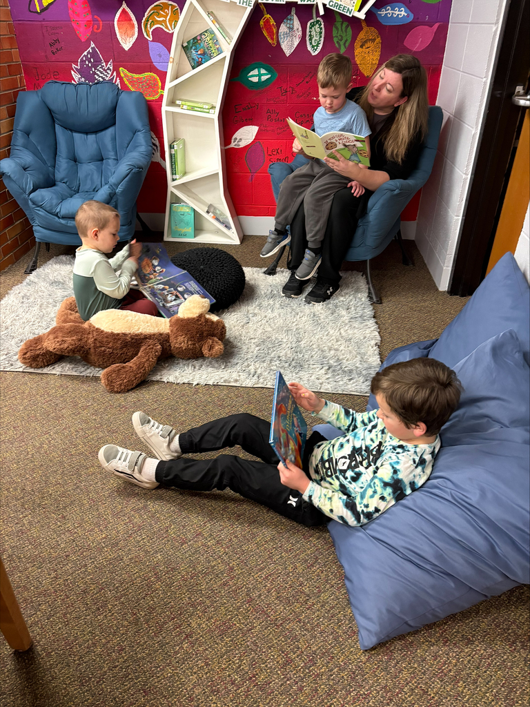 preschool students in a library reading with a woman