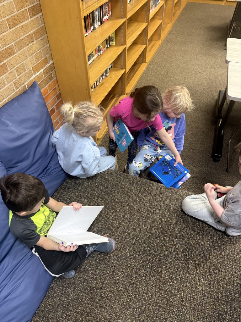 group of kids sitting in a library reading