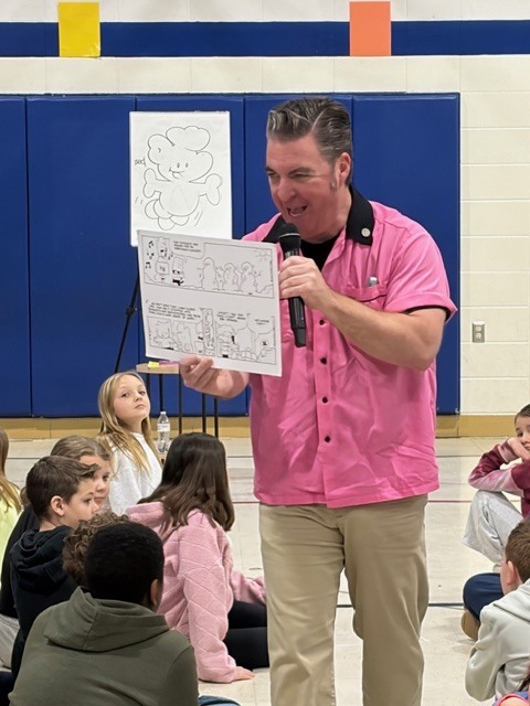 man showing students a comic drawing