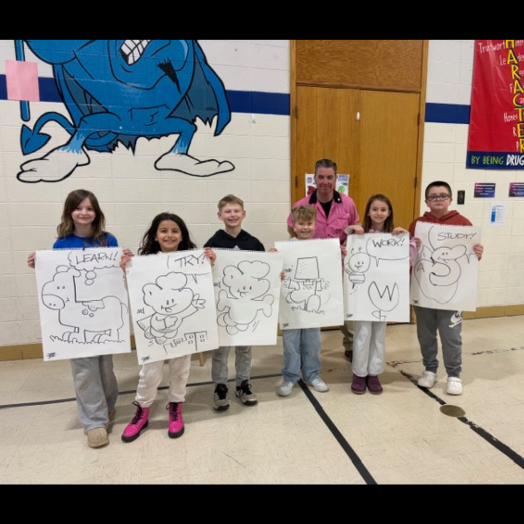 man posing with students holding large drawings of a cartoon