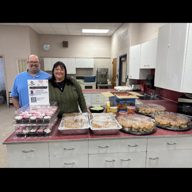 man and woman standing in front of a counter of food