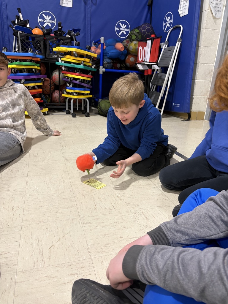 students sitting in a circle in a gym