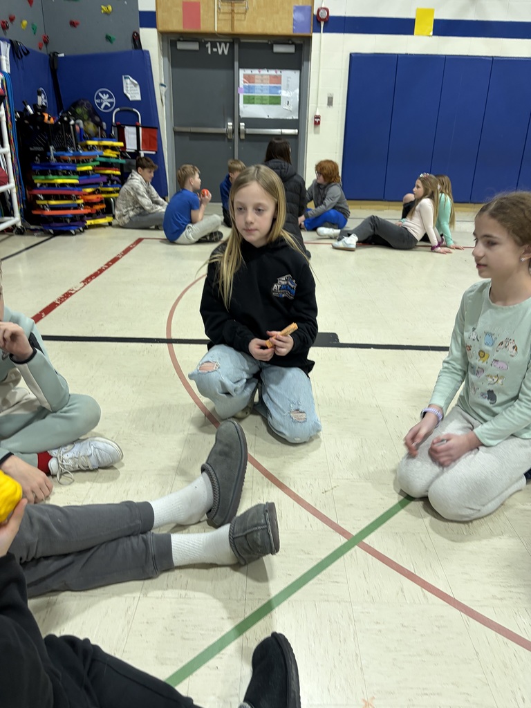 students sitting in a circle in a gym