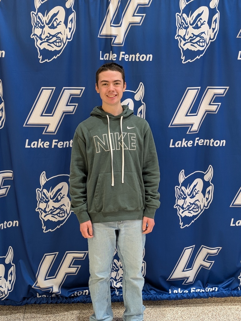 boy posing in front of Lake Fenton  backdrop