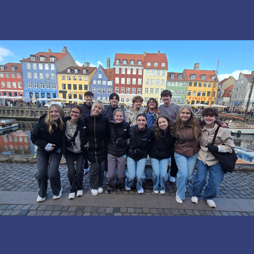 group of students standing in front of colorful buildings