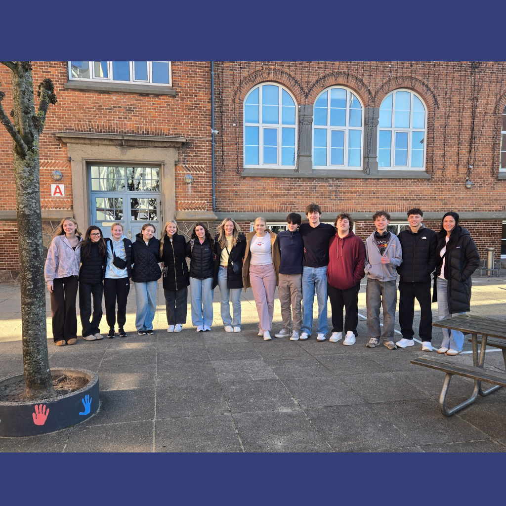 group of students standing in front of a building