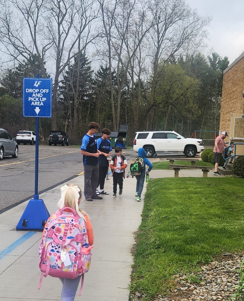 high school baseball players helping elementary students outside school